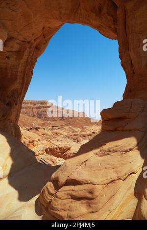 Dies ist die Landschaft der Arava-Wüste in Israel durch ein erosives Steinfenster im Felsen. Stockfoto