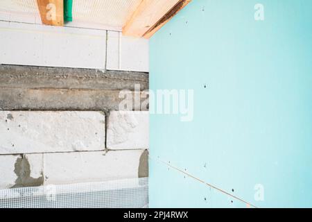 Andocken einer mit Gipskarton ummantelten Wand an eine Wand aus Porenbeton. Interne Arbeiten beim Bau des Hauses Stockfoto