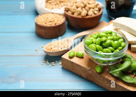 Frische grüne Sojabohnen und andere organische Produkte auf hellblauem Holztisch. Platz für Text Stockfoto