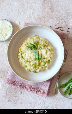 Italienisches Risotto mit Spargel und Parmesankäse auf dem Tisch. Draufsicht. Stockfoto