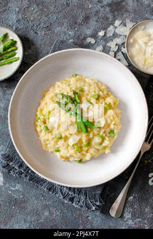 Italienisches Risotto mit Spargel und Parmesankäse auf dem Tisch. Draufsicht. Stockfoto