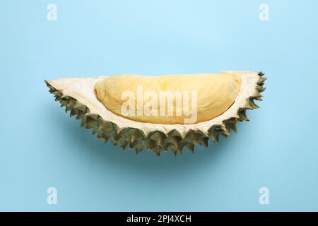 Ein Stück frische, reife Durianfrucht auf hellblauem Hintergrund, Draufsicht Stockfoto