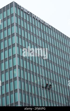 Hamburg, Deutschland. 31. März 2023. Fensterreiniger Seilen sich an der Fassade des ehemaligen Hamburger Süd-Hauses ab, das heute Trio Hamburg heißt. Kredit: Christian Charisius/dpa/Alamy Live News Stockfoto