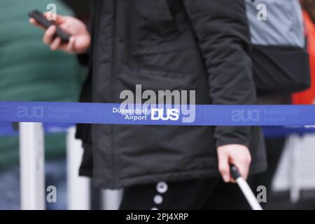 Düsseldorf, Deutschland. 31. März 2023. Am Flughafen Düsseldorf warten mehrere Passagiere mit ihrem Gepäck auf den Check-in. Die Warteschlangen sind durch blaue Bänder getrennt. Kredit: David Young/dpa/Alamy Live News Stockfoto
