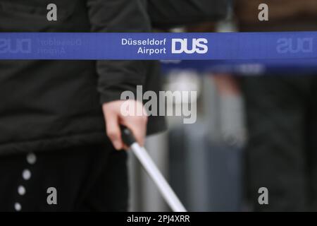 Düsseldorf, Deutschland. 31. März 2023. Am Flughafen Düsseldorf warten mehrere Passagiere mit ihrem Gepäck auf den Check-in. Die Warteschlangen sind durch blaue Bänder getrennt. Kredit: David Young/dpa/Alamy Live News Stockfoto
