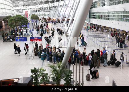 Düsseldorf, Deutschland. 31. März 2023. Am Flughafen Düsseldorf warten mehrere Passagiere mit ihrem Gepäck auf den Check-in. Kredit: David Young/dpa/Alamy Live News Stockfoto