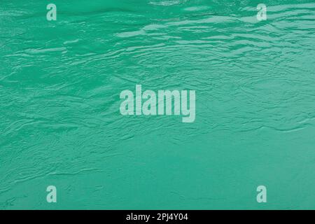 Die Textur der türkisfarbenen Wellen des schnell fließenden Wassers im Fluss. Abstrakter Naturhintergrund. Stockfoto