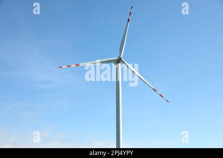Moderne Windturbine vor blauem Himmel. Alternative Energiequelle Stockfoto
