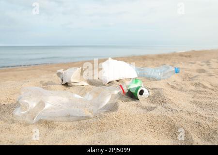 Müll verstreut am Strand in der Nähe des Meeres. Recycling-Problem Stockfoto