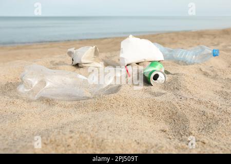 Müll verstreut am Strand in der Nähe des Meeres. Recycling-Problem Stockfoto