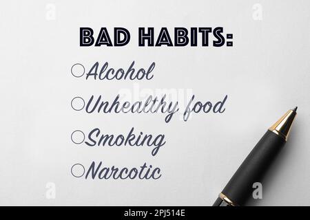 Liste der schlechten Gewohnheiten und Stift auf weißem Papier, Draufsicht. Ändern Sie Ihren Lebensstil Stockfoto