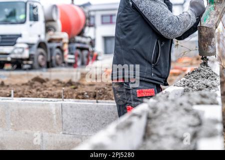 Beton aus einem Mischwagen mit Schlauch in das Fundament des Hauses gießen Stockfoto