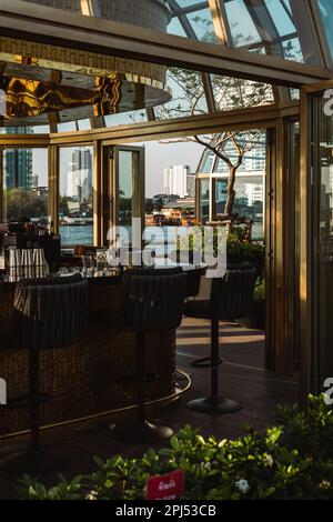 Ein gehobenes Restaurant mit einer modernen Fassade und einer großen Außenterrasse für Speisen im Freien Stockfoto