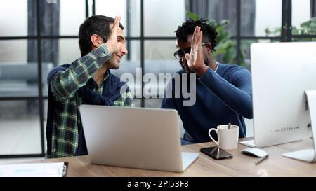 Zwei Geschäftsleute geben High Five im Büro, um sich zu motivieren Stockfoto