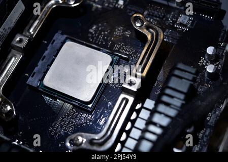 Wärmeleitpaste auf die Oberfläche des Computerprozessors auftragen. Thermische Schnittstelle auf dem Prozessor. Stockfoto