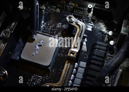 Wärmeleitpaste auf die Oberfläche des Computerprozessors auftragen. Thermische Schnittstelle auf dem Prozessor. Stockfoto