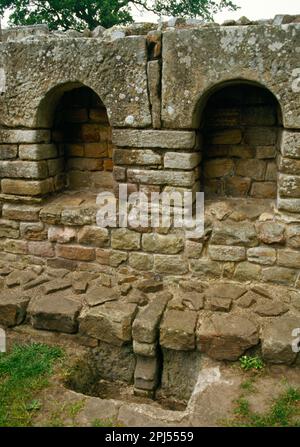 Chesters Römisches Fort Bath House. 2 Nischen in der Westwand des Umkleideraums, mit Steinfangmulde und früherem Bodenniveau in der Grube. Stockfoto