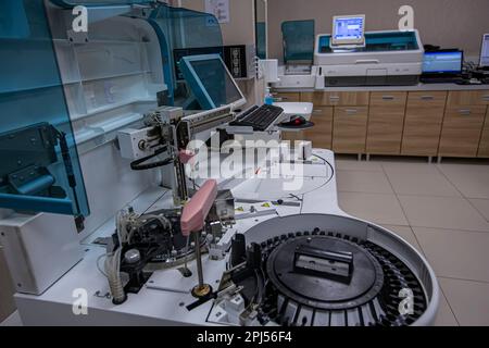 Bluttestmessgeräte im Labor. Blutanalyse im automatischen biochemischen Analysegerät. Medizinisches Labor. Qualitätskontrolle des Laboratoriums Stockfoto