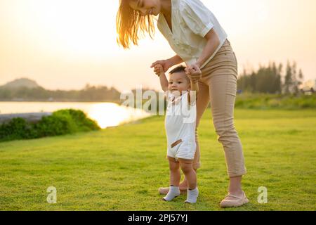 Glückliche Familie, Mutter und Sohn, die zusammen im Green Meadow Park spielen Stockfoto