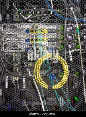 Gelbes Spiralkabel zur Verbindung von Digital Equipmnet, das in einem Rack installiert ist Stockfoto