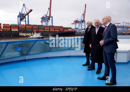 Hamburg, Deutschland. 31. März 2023. Der britische König Karl III. (M) steht neben dem deutschen Präsidenten Frank-Walter Steinmeier (l) und Peter Tschentscher (SPD), dem ersten Bürgermeister von Hamburg, während einer Bootstour im Hafen von Hamburg. Am Ende ihrer dreitägigen Reise nach Deutschland besuchen der britische König und seine Frau die Hansestadt Hamburg. Kredit: Matthias Schrader/Pool AP/dpa/Alamy Live News Stockfoto