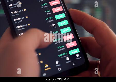 Geschäftsmann, der die Börse mit dem Smartphone überprüft. Mann, der ein Mobiltelefon mit einer Investitionsanwendung verwendet. wertpapieranlagen und Handel cr Stockfoto