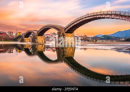 Iwakuni, Yamaguchi, Japan in der Kintaikyo Brücke über den Nishiki Fluss in der Dämmerung. Stockfoto