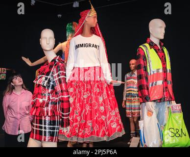 London, Großbritannien. 31. März 2023. Galeriepersonal mit mehreren Outfits, darunter das berühmte „Immigrant“-T-Shirt (Mitte), eine Reaktion auf den Brexit, den Ashish bei seinen Frühjahrsshows in London im Jahr 2017 trug. William Morris Gallery enthüllt eine große Ausstellung des Modedesigners Ashish. Ashish Gupta ist ein Modedesigner, dessen Signatur Pailletten und Perlen sind und sein indisches Erbe nutzen. Sein gleichnamiges Label greift auf sein Erbe zurück, mit Stücken, die von Madonna, Lady Gaga, taylor Swift und vielen anderen getragen wurden.bis zum 10. September 2023 werden über 60 Designs aus den letzten 20 Jahren ausgestellt. Kredit: Imageplotter/Alamy Live News Stockfoto