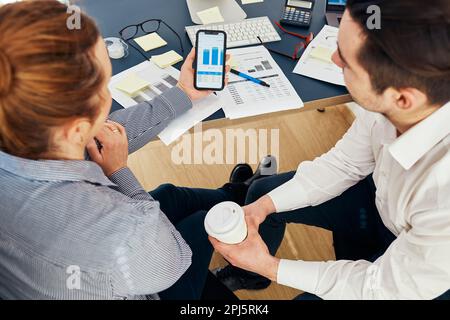 Geschäftskollegen diskutieren gemeinsam im Büro über Finanzdaten. Menschen Unternehmer, die mit Diagrammen und Tabellen auf Computer und Smartpho arbeiten Stockfoto