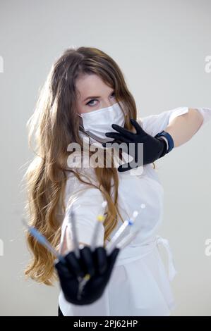 Der Zahnarzt hält in seinen Händen zahnärztliche Instrumente, gekleidet in schwarzen Handschuhen, Nahaufnahme. Zahnheilkunde. Hohe Qualität Stockfoto