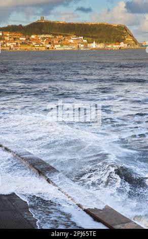 Schweres Meer in Scarborough mit Altstadt und Hafen im Hintergrund Stockfoto