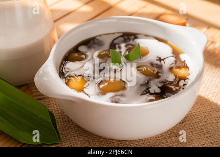 Bubur Candil oder indonesischer Reismehl-Porridge mit klebrigen Reisbällchen aus Süßkartoffeln, serviert mit Palmzuckersauce in einer weißen Schüssel Stockfoto