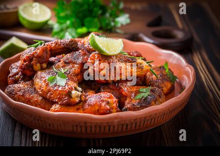 Heiße und spicey Buffalo Chicken Wings mit Zutaten auf Holzhintergrund Stockfoto