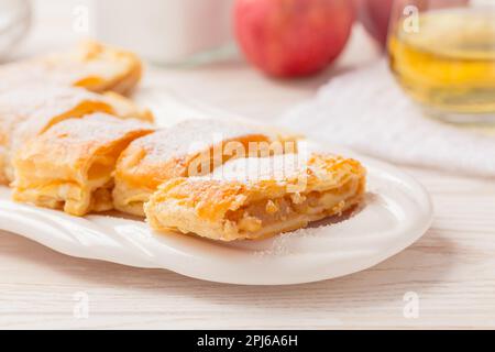 Hausgemachter Apfelstrudel (Apfelstrudel) auf weißem Teller. Beliebter Kuchen in Europa Stockfoto
