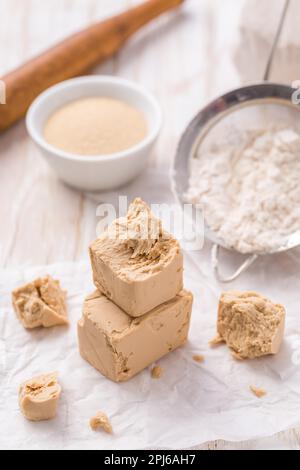 Frische und getrocknete Hefe mit Backzutaten auf weißem Hintergrund Stockfoto