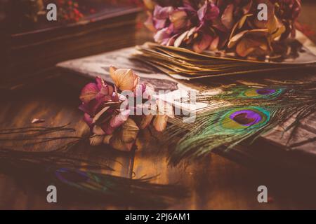 Erinnerungen - Altes Buch und Fotoalbum, getrocknete Blumen und Pfauenfederauge im Vintage-Stil Stockfoto