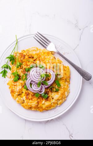 Tortilla: spanisches Omelett mit Kartoffeln, Zwiebeln und Kräutern auf weißem Hintergrund Stockfoto