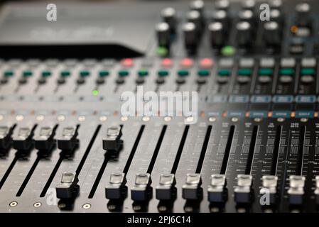 Ein professionelles Aufnahmestudio mit einer Vielzahl elektronischer Musikgeräte und Sound-Mischkonsolen auf einem Tisch Stockfoto