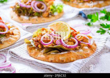 Griechisches Gyros-Fleisch mit Pita-Fladenbrot, Gemüse und Zwiebeln und Tzatziki-Dip auf weißem Hintergrund Stockfoto