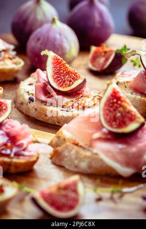 Kleine, offene Sandwiches mit Ciabatta, Proscuitto und frischen Feigen als Appetizer Stockfoto