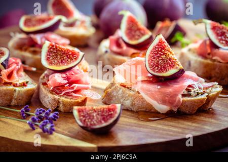 Kleine, offene Sandwiches mit Ciabatta, Proscuitto und frischen Feigen als Appetizer Stockfoto