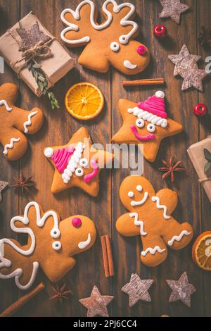 Lebkuchenkekse mit traditionellen Gewürzen zur Weihnachtszeit auf Holztisch Stockfoto