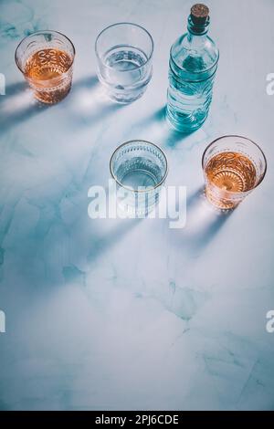 Wasser in Vintage-Gläsern mit Flasche Stockfoto