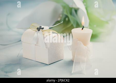 Erste heilige Kommunion oder Bestätigung - Kerze, kleines Geschenk und Blumen Stockfoto