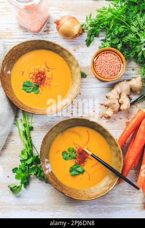 Hausgemachte rote Linsensuppe mit Karotten, Ingwer und Kokosmilch mit Zutaten Stockfoto