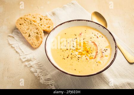 Köstliche cremige Chilikäse-Maissuppe mit Brot serviert Stockfoto