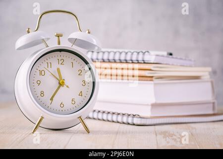 Zeitmanagement-Konzept für Schüler und Studenten. Bücher mit Uhr Stockfoto