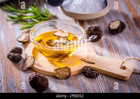 Trüffelpilzöl auf Holzhintergrund. Gourmetessen Stockfoto