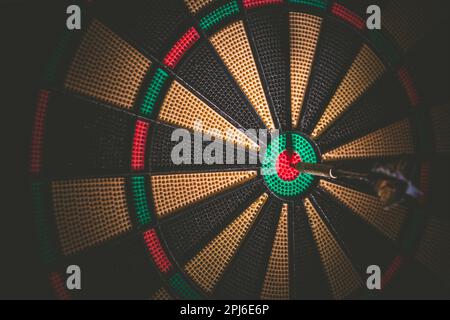Geschäftskonzept - Ziel und Ziel als Konzept. Dartpfeil traf auf Bulleyes von Dartscheibe, um zu zeigen, dass das Unternehmen das Ziel erreicht hat Stockfoto