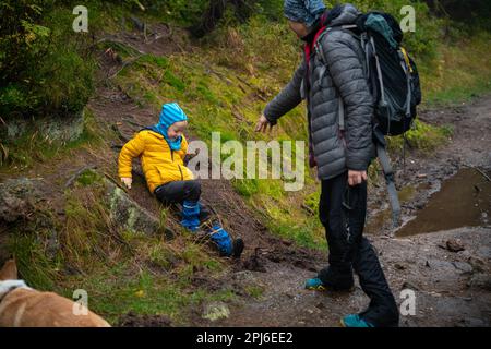 Das Kind rutschte aus und fiel auf den geneigten, nassen Boden. Polnische Berge, Polen, Europa Stockfoto
